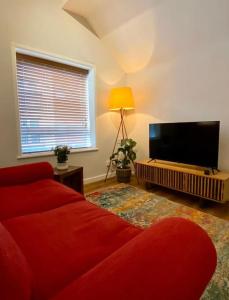 克鲁Central Crewe - Modern 1BR Haven的客厅配有红色沙发和平面电视