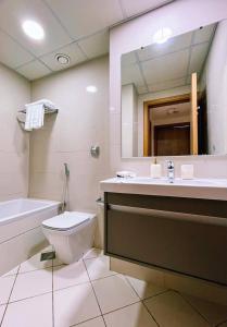 迪拜Lux High Rise Marina Apartment的一间带卫生间、水槽和镜子的浴室