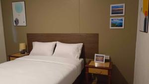 班武里府The Monkey Resort Donheang的一间卧室配有一张床和两张带照片的桌子