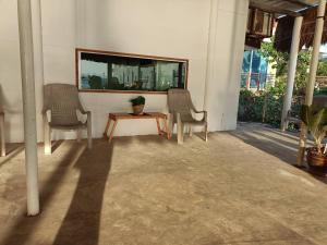 南芭堤雅Chuencheewa Resort的门廊上的两把椅子和一张桌子