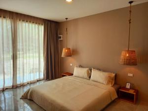 库德岛Koh Kood Club的一间卧室配有一张大床和两盏灯。