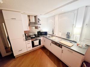 不莱梅Smartpartment Hemelingen - Shared apartment的厨房配有白色橱柜和黑色台面
