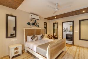 果阿旧城Le dando Beach Resort by Orion Hotels的一间卧室配有一张大床和两面镜子