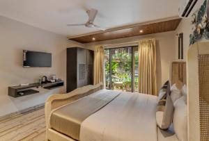 果阿旧城Le dando Beach Resort by Orion Hotels的一间带大床和电视的卧室