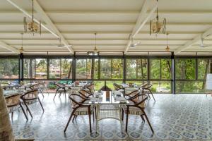 果阿旧城Le dando Beach Resort by Orion Hotels的用餐室设有桌椅和窗户。