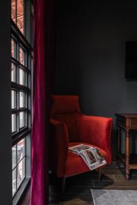 顺化The Chum Boutique的窗户房间里一张红色的沙发