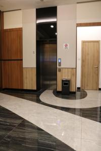 雅加达Grand Ametis Hotel Jakarta的大堂设有两部电梯和一扇门,位于大楼内