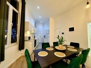 蒙斯Luxury Suites Mons的一间带桌子和绿色椅子的用餐室