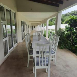 蓬塔杜欧鲁Tropicana guesthouse的庭院里的白色餐桌和椅子