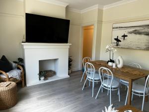 悉尼Little Manly 3 bedroom Oasis的客厅设有壁炉、桌子和椅子