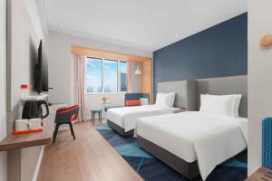 潍坊潍坊中心智选假日酒店的酒店客房配有两张床和一张书桌
