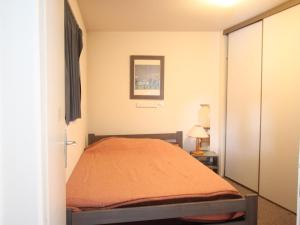 尚鲁斯Appartement Chamrousse, 3 pièces, 6 personnes - FR-1-340-275的一间卧室配有一张带橙色毯子的床