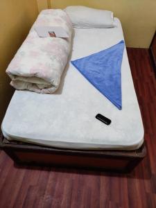 RaxaulHotel Dharam Mukti Utsav Bhawan (DMUB)的一张床上有蓝色纸张的床铺