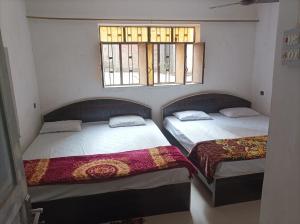 RaxaulHotel Dharam Mukti Utsav Bhawan (DMUB)的带2扇窗户的客房内的2张床