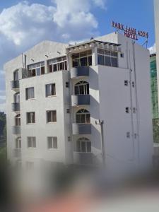 亚的斯亚贝巴Park Lane Addis Hotel的白色的建筑,上面有标志