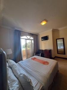 亚的斯亚贝巴Park Lane Addis Hotel的一间设有大床和窗户的酒店客房