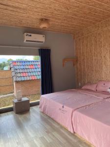 Xuyên MộcViệt Kiều Royal的卧室配有粉红色的床和窗户。