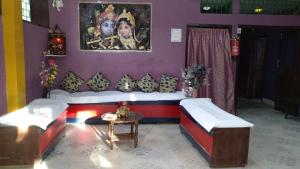 RaxaulHotel Dharam Mukti Utsav Bhawan (DMUB)的客房设有两张床、一张桌子和一幅画