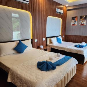 Thôn Thái AnKhu du lịch Hang Rái - Ninh Thuận的一间卧室配有两张带蓝色枕头的床