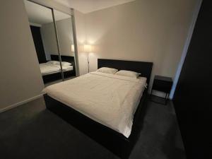 堪培拉New modern 1BR apt near Dickson的一间卧室配有一张大床和镜子