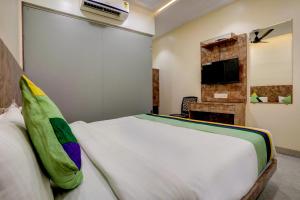 孟买Kiwi International,Hotel,Mumbai的卧室配有白色的床和电视