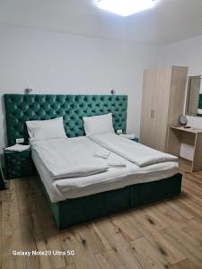 弗格拉什LukAmi Green Home的一间卧室配有一张大床和绿色床头板