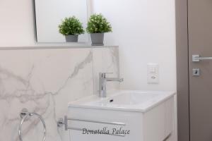 卢加诺Elegant Apartments in Lugano的浴室设有水槽和两盆植物