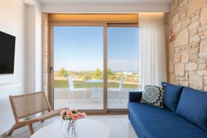 阿菲托斯Anna Mare Luxury Apartments的客厅配有蓝色的沙发和桌子