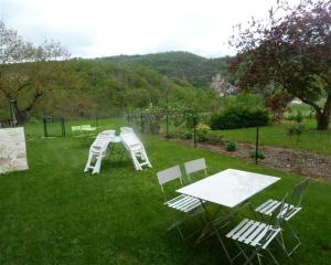 贝尔卡斯泰chambre d'hôtes Cadravals Belcastel Aveyron的草上一组椅子和一张桌子