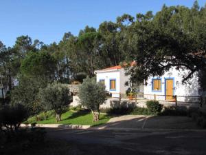 蒙希克昆塔达埃达利纳农家乐的白色的小房子,有蓝色的门和树木