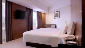 三宝垄桑提卡三宝垄酒店的配有一张床和一台平面电视的酒店客房