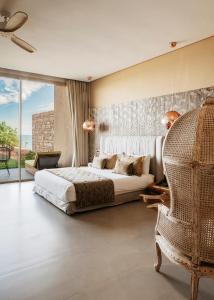 达赫拉Bavaro Beach Dakhla的一间卧室配有一张大床和一把椅子