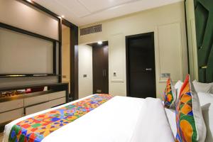 卢迪亚纳FabHotel Prime K9 Crown的一间卧室配有一张床和一台平面电视