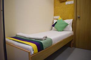 孟买ZEST STAYS - IIT的一张小床,上面有五颜六色的毯子