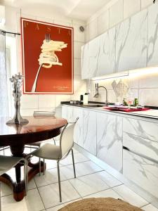 阿斯蒂ComeCasa Alfieri Elegant Apartment的厨房配有木桌和红色绘画