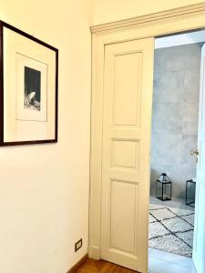 阿斯蒂ComeCasa Alfieri Elegant Apartment的一间有门的房间,墙上挂着一张照片