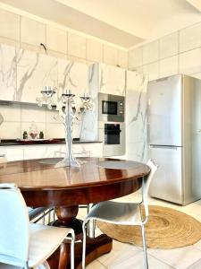 阿斯蒂ComeCasa Alfieri Elegant Apartment的厨房配有木桌和冰箱。
