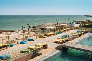 达赫拉Bavaro Beach Dakhla的一个带游泳池和椅子的度假胜地和大海