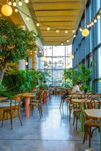 巴黎The People - Paris Marais的一间空餐厅,配有桌椅和植物