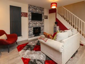 雷克瑟姆2 Stoneleigh Cottage的客厅配有白色沙发和壁炉