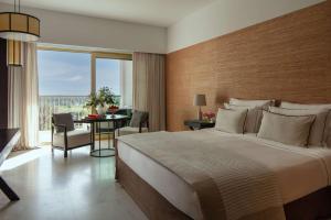 维拉摩拉Anantara Vilamoura Algarve Resort的一间带大床的卧室和一间餐厅