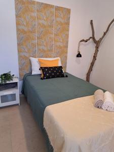 阿罗纳芬卡奇玛卡酒店的一间卧室配有两张带绿床单和橙色枕头的床