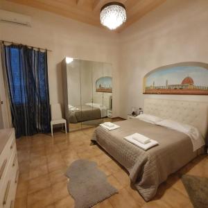 佛罗伦萨学院一室公寓酒店的一间卧室配有一张大床和镜子