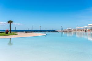 普拉亚布兰卡Barceló Playa Blanca的海滩旁的蓝色大泳池