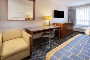 马纳萨斯马纳萨斯/66号州际公路戴斯酒店的酒店客房配有书桌、床和椅子。