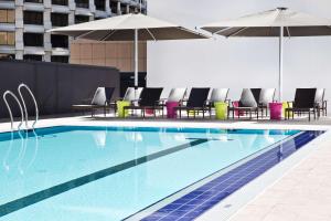 布里斯班布里斯班希尔顿酒店的一个带椅子和遮阳伞的大型游泳池