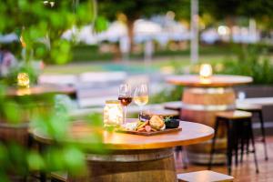凯恩斯凯恩斯希尔顿逸林酒店的一张桌子,上面放着两杯葡萄酒和一盘食物