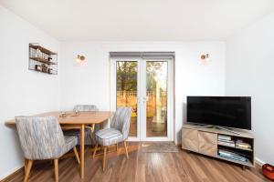 伦敦Charming 1BR flat with patio perfect for couples的一间带桌子和电视的用餐室