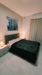 卢加Fairwinds - Double Room with Ensuite - Luqa Airport - Self Check In & Out available的卧室配有一张床,墙上挂有绘画作品