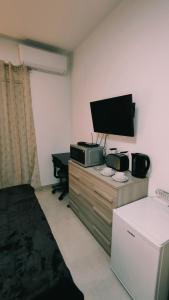 卢加Fairwinds - Double Room with Ensuite - Luqa Airport - Self Check In & Out available的一间房间,配有带床铺的梳妆台上配有电视